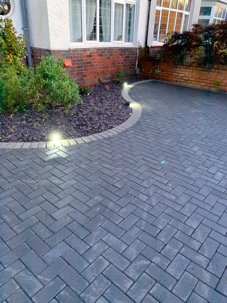 Dark block paved driveway with recessed lighting