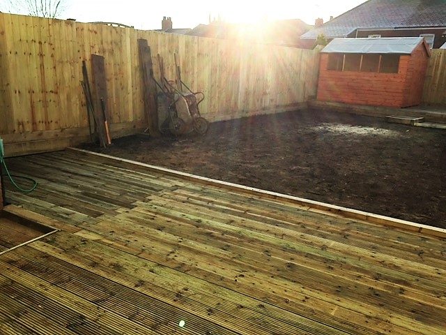Timber deck across the rear of a fenced garden