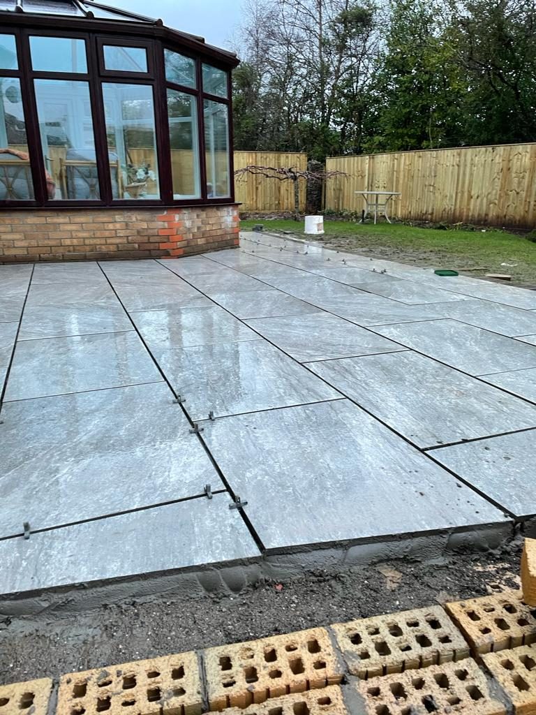 Finished grey slab patio beside a conservatory