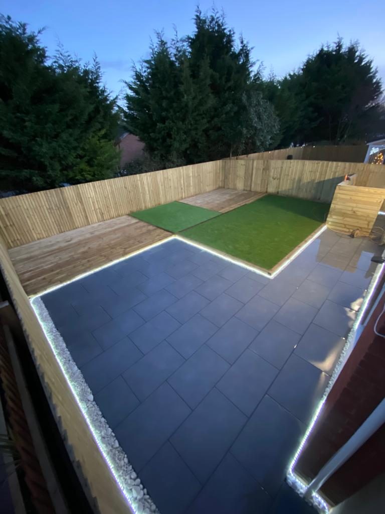 Modern rear garden combining decking, paving and lawn
