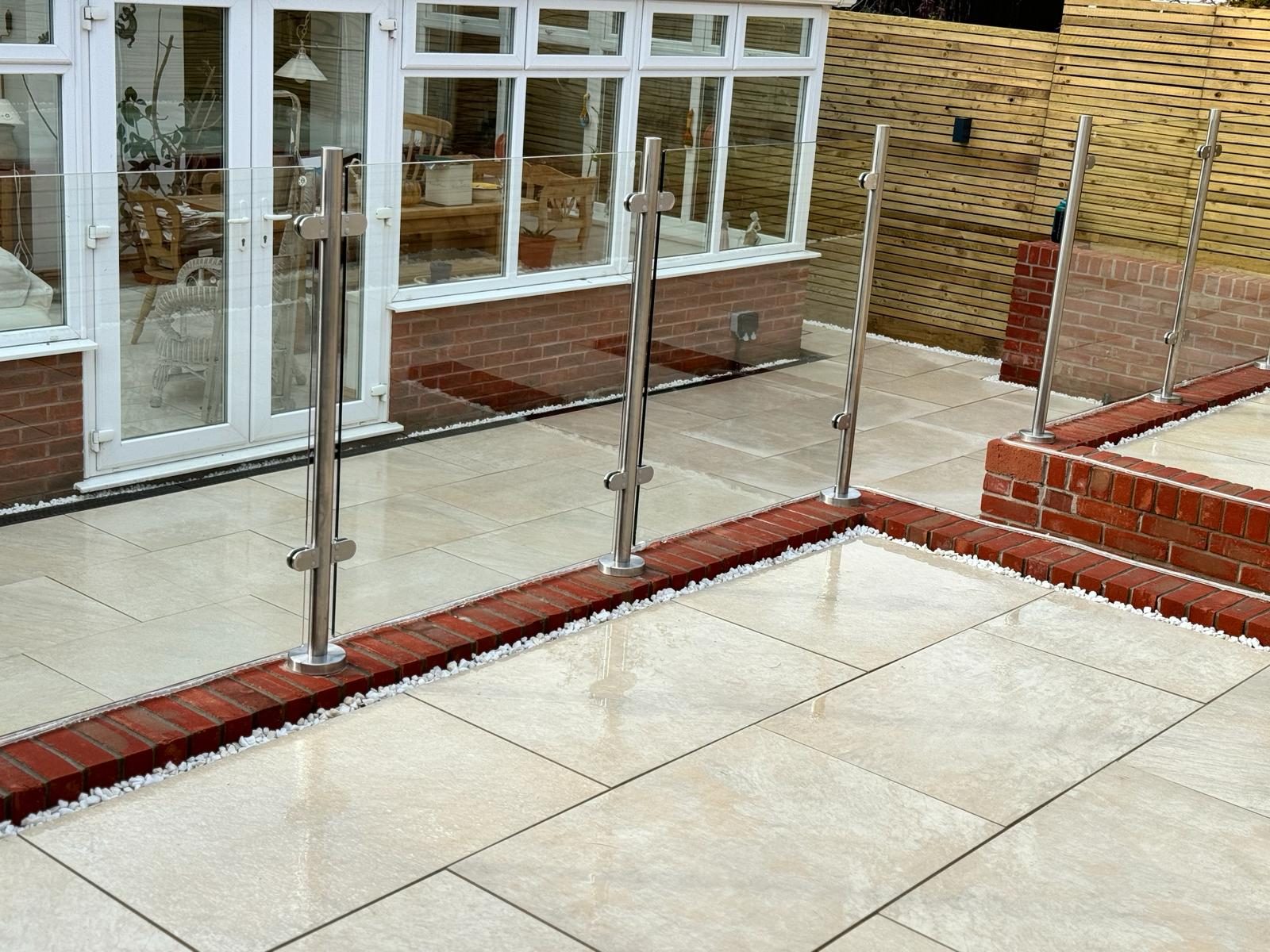 Light paving with brick edging and glass railing