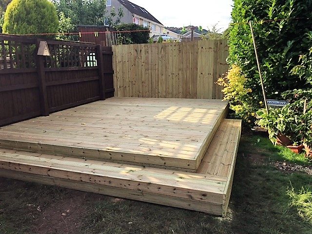 Small raised timber deck with steps in a garden
