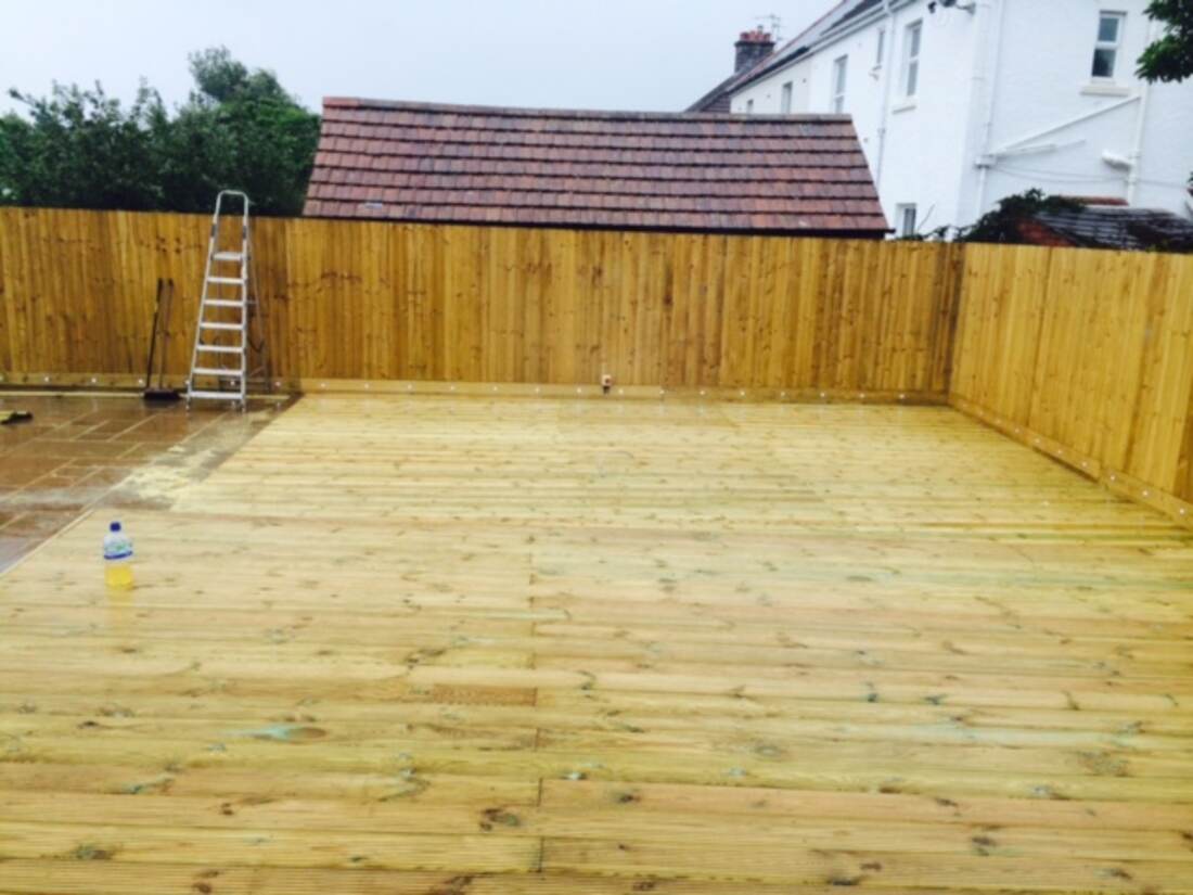 Large timber deck spanning the width of a rear garden