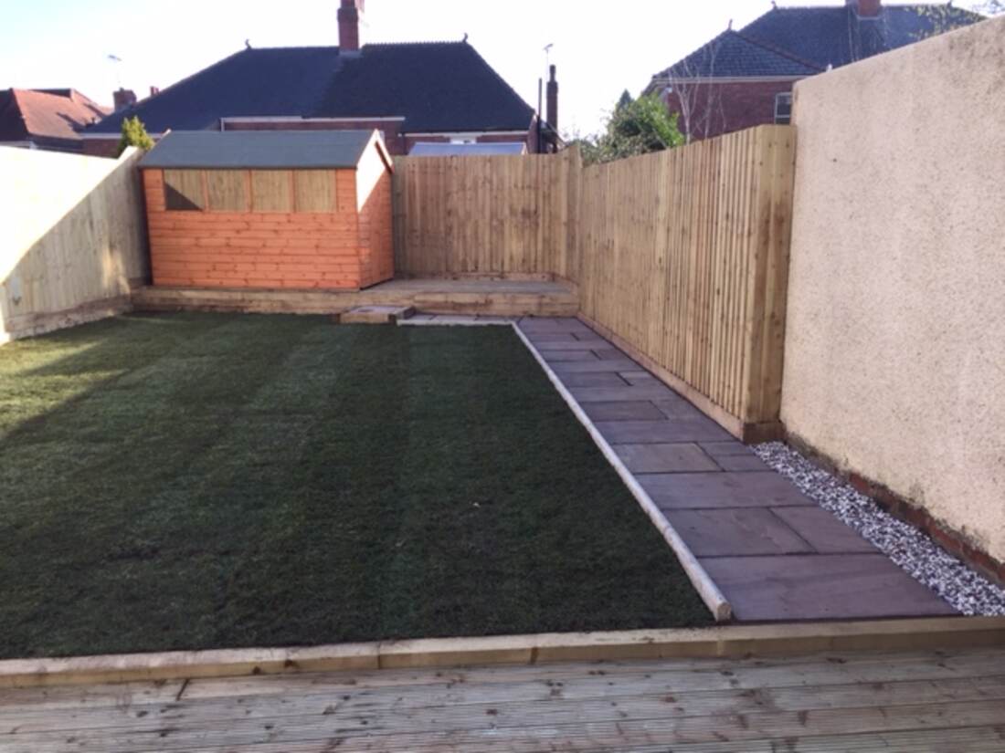 Restored rear garden with fresh turf, sleeper edging and a paved path